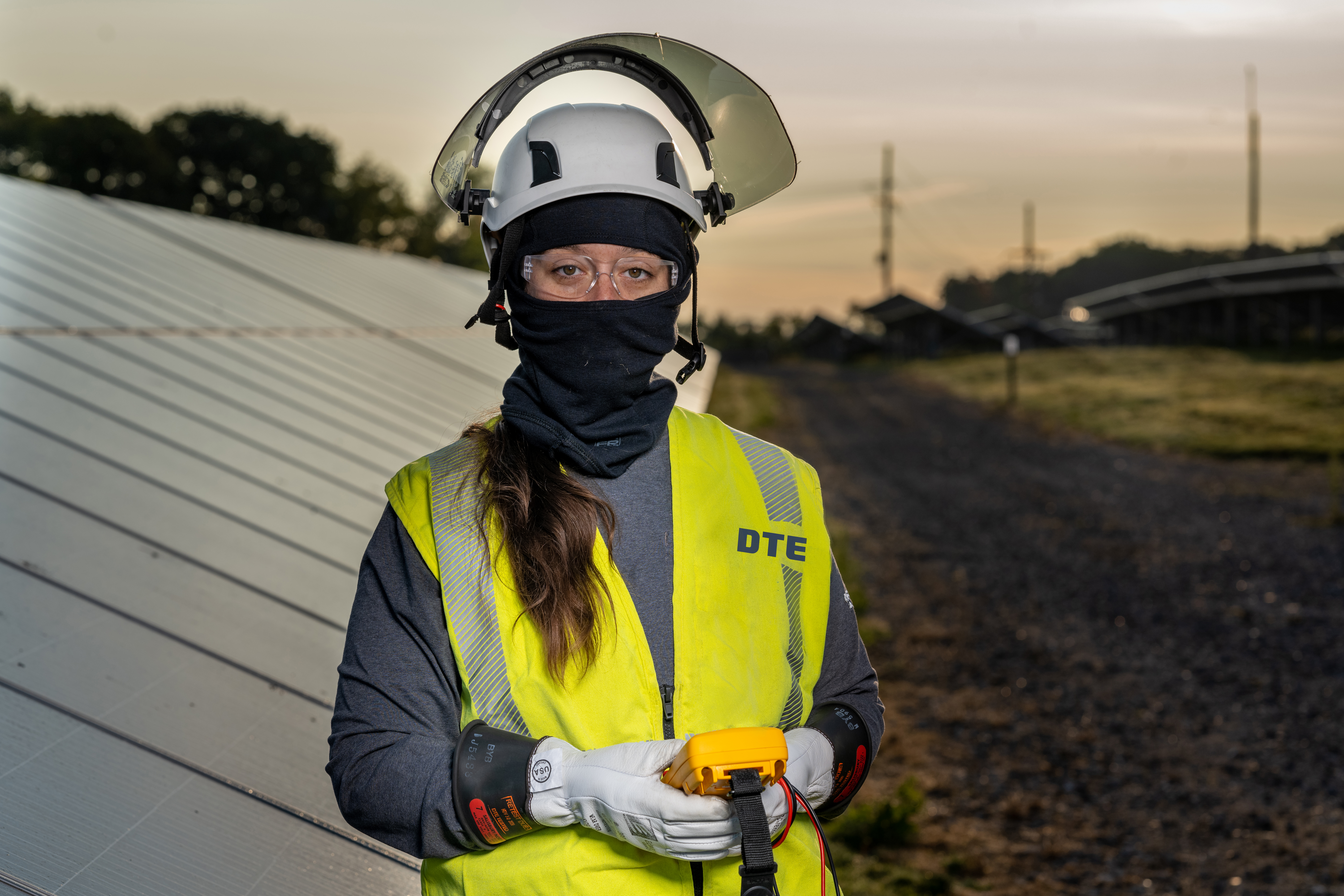 Female worker standing in front of a solar panel