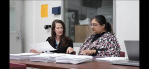 Woman assists female colleague with legal support for returning citizen clinic participant files.