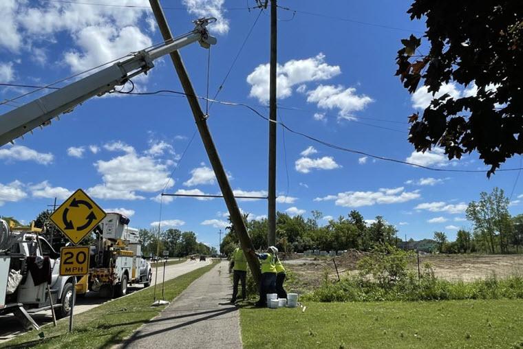 DTE workers standing up a utility pole