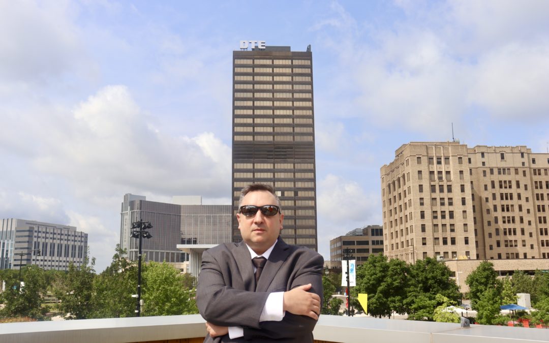 Image of a man standing in front of DTE HQ