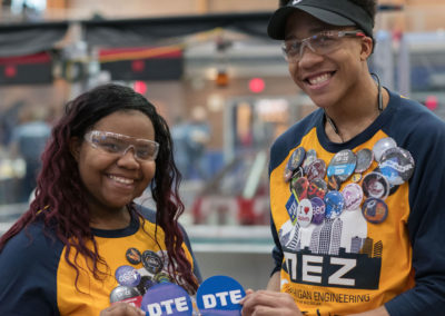 Students from team 2224 RoboPhoenix hold up DTE stickers